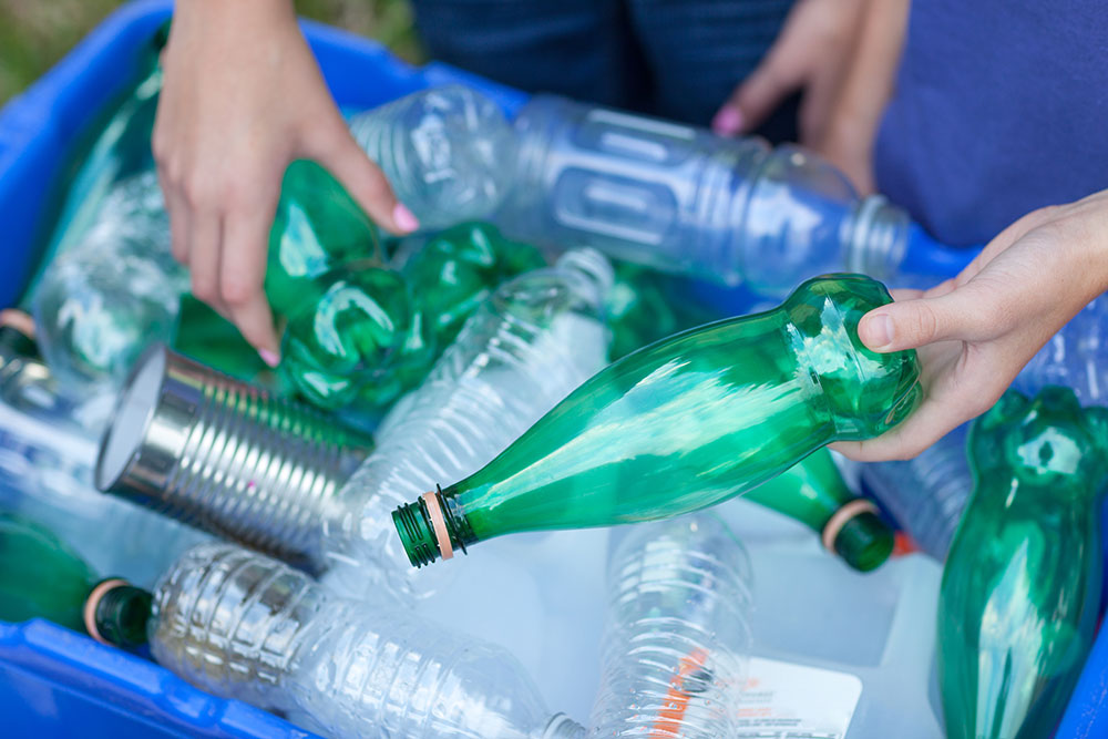 People's hands recycling bottles and cans