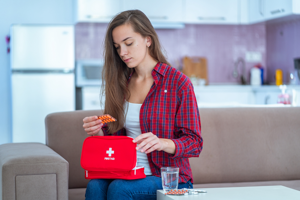 A woman inspects her at home first aid kit