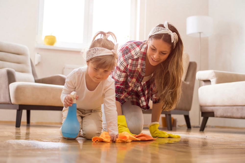 A mother and daughter work together to clean up their living room at the St. Joseph apartments