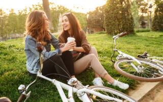 Two women stop to drink coffee after their bike ride