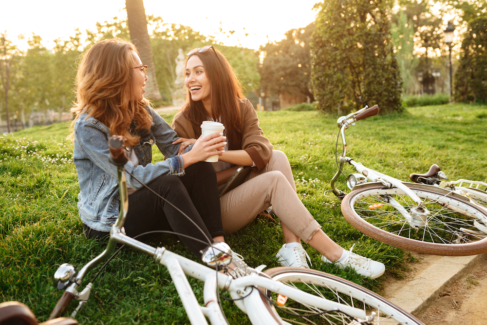 Two women stop to drink coffee after their bike ride