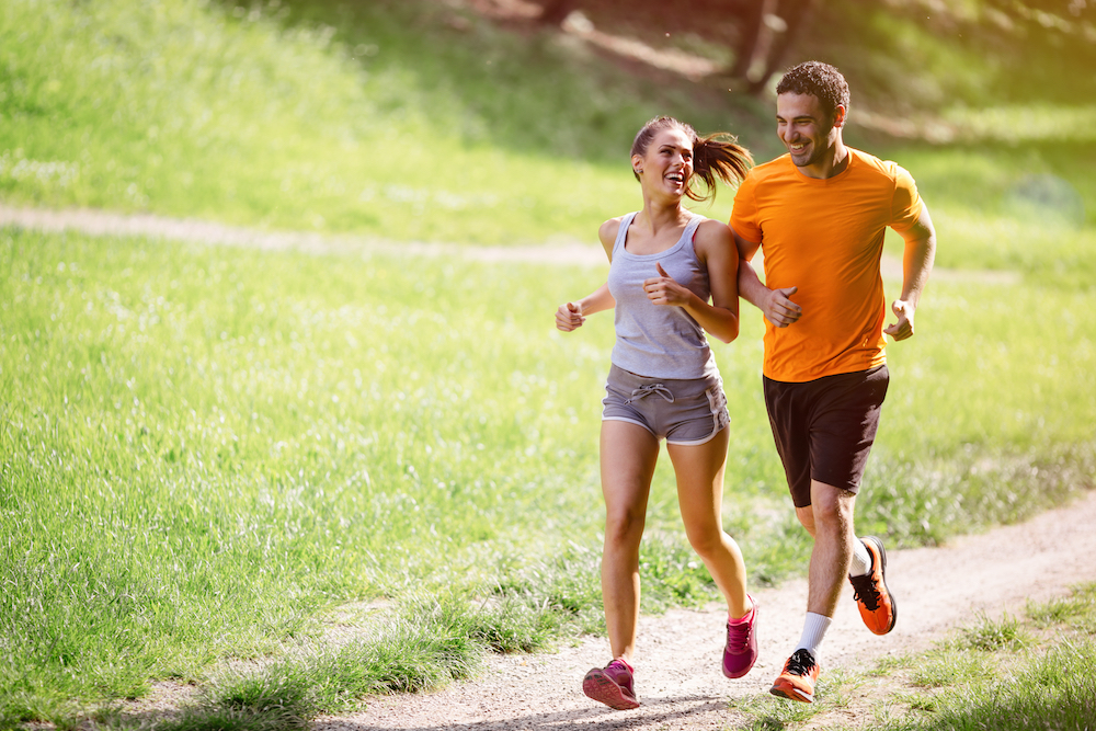 A young couple goes on a jog together at a local park