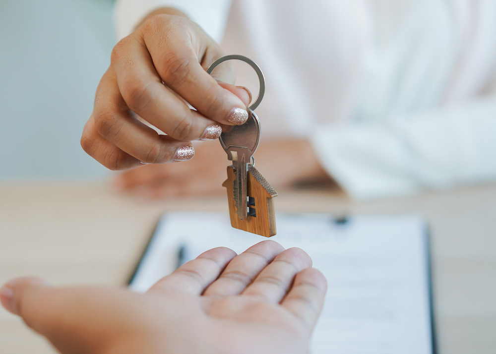 An apartment manager hands over keys to renter