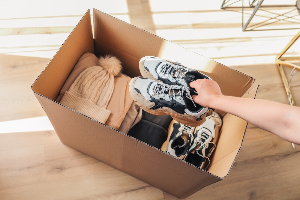 A woman packing up shoes into a box to move
