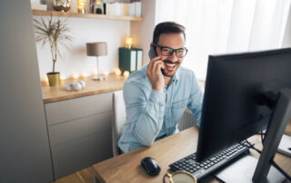 A happy young businessman talks on the phone at his home office at the apartments in St. Joe mo