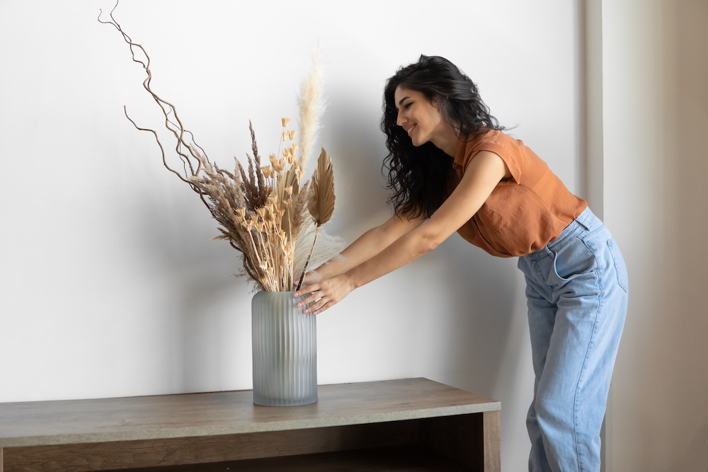 A woman decorating her loft at the Saint Joe apartments using flowers