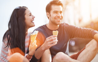 A young happy couple eating ice cream on a date not too far from the St. Joseph apartments