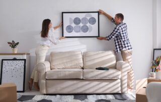 A young couple hanging up artwork in their new home at the apartments in Saint Joseph, MO