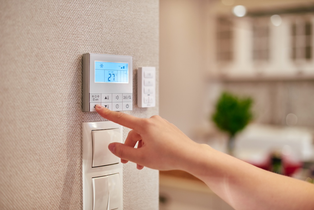 Woman hand adjusting temperature / thermostat